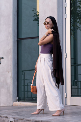 Woman posing in white palazzo pants and a fitted top