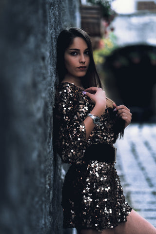 Girl laying on the wall and wearing a sequin mini dress