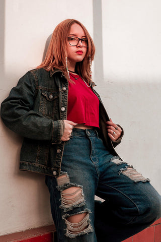 Girl laying on the wall and wearing black denim jacket and ripped jeans