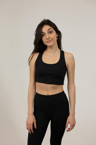 Young woman posing with a crop top and black leggings