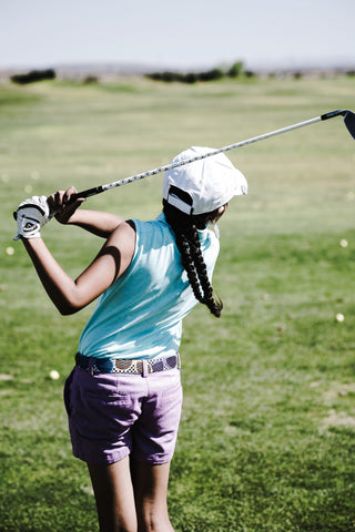 A girl playing golf wearing a colorful golf attire