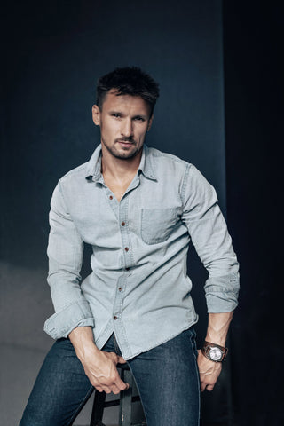 Man posing in a denim outfit with a shirt and jeans