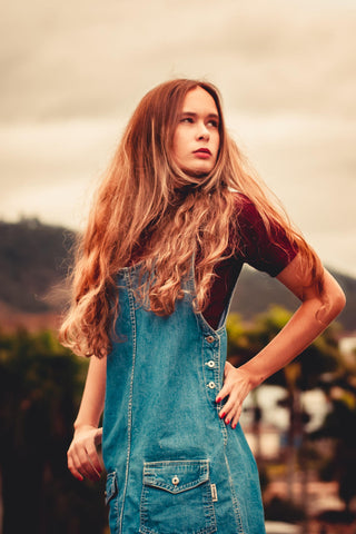 Girl posing with blue overalls and a basic tee under it