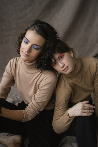 close photo of two women wearing turtlenecks