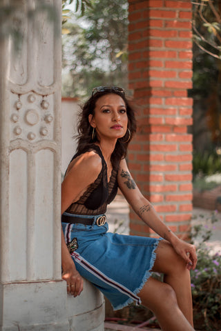 Woman posing in black lace top and denim skirt