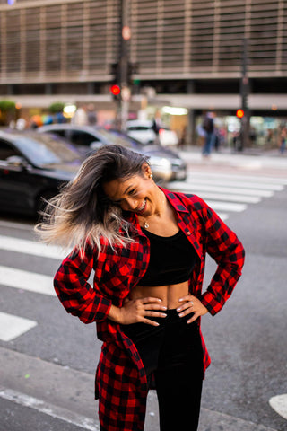 Girl smiling wearing a flannel shirt over leggings and a crop top