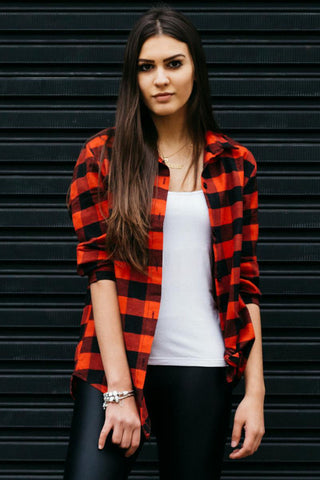 Woman posing with a flannel shirt and black leggings