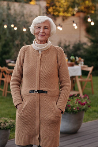 Elderly woman posing with beige long cardigan