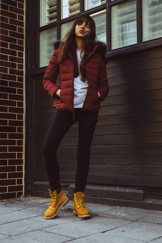 Young woman posing with a winter jacket and black skinny jeans