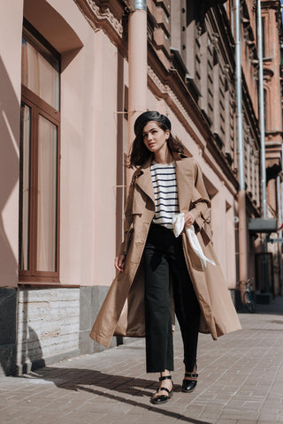 Femme marchant en jeans décontractés et tenue trench-coat