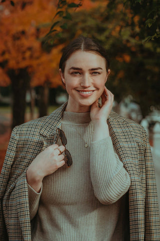 Close photo of a woman wearing a turtleneck and a coat