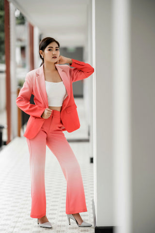 woman posing with coral two-piece suit and a crop top