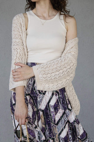 woman posing with a cozy cardigan over a tank top and a skirt