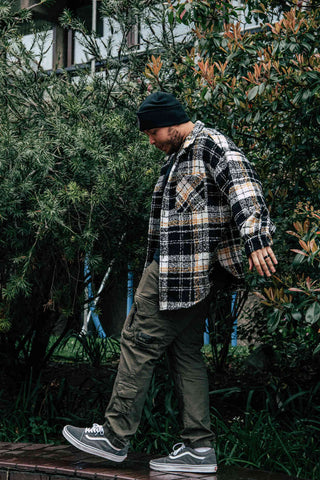 Man posing with cargo pants and a flannel shirt