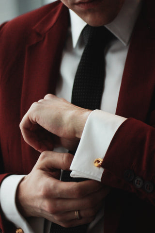 Close shot of a man in a suit and gold cufflinks