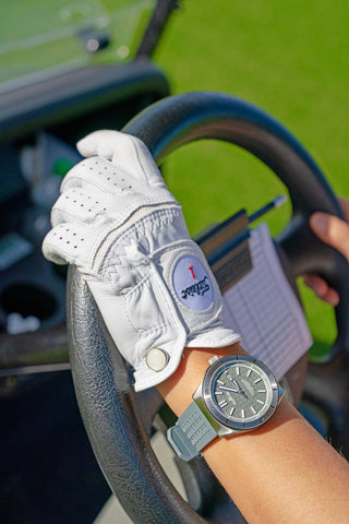 Photo d'un gant de golf d'une personne conduisant une voiturette de golf