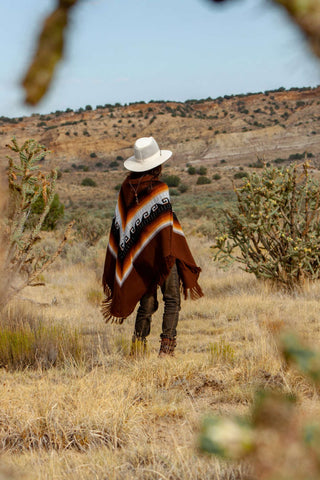 Photo of a woman wearing a poncho and a white cowboy hat