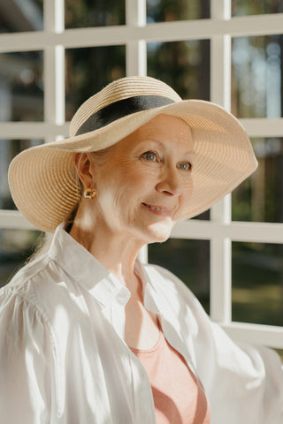Mature woman posing with a wide-brimmed hat