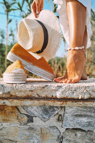 Close photo of espadrilles and a straw hat
