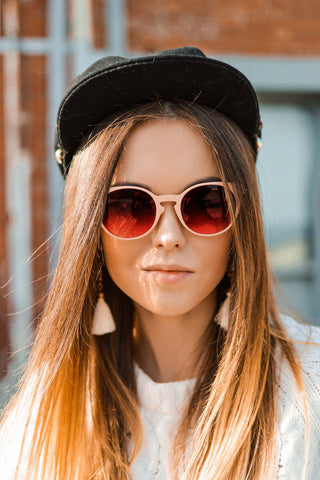 Close photo of a woman wearing a hat and sunglasses