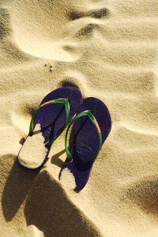 Photo of flip-flops on a sandy beach