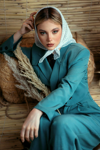 Woman posing with a blue suit and a foulard covering her head