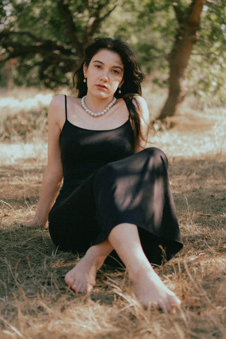 Woman posing with a black slip-on dress