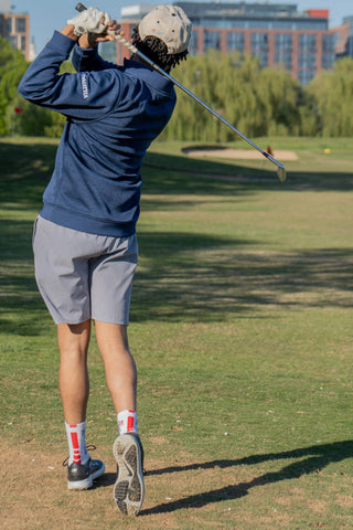Une photo du dos d'un homme jouant au golf avec des vêtements et des chaussures de golf