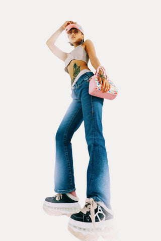 Femme posant en jean évasé et un crop top