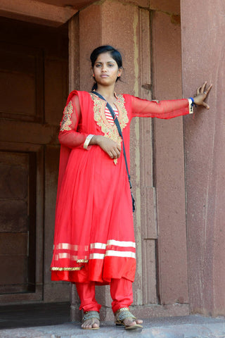 Indian woman in red chikankari kurta and kolhapuri