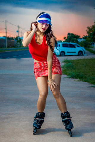 Woman posing with roller skates wearing red mini skirt and a tank top
