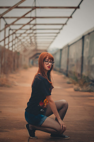 Girl posing with denim shorts and fishnet tights