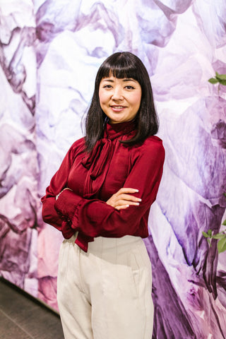 Woman posing for a photo wearing red blouse and tailored pants