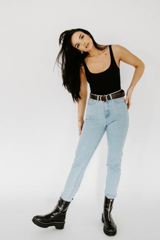 Girl posing with high waist jeans, a tank top, and combat boots