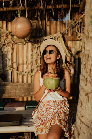 Happy woman with a mini skirt and white top in a tropical-themed bar