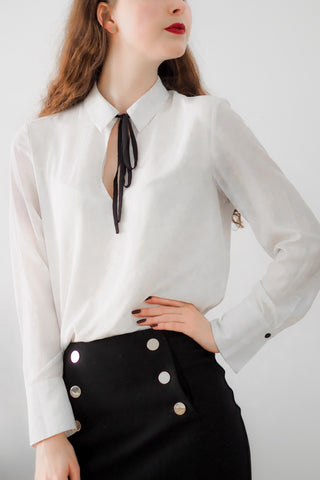 Woman torso in a white blouse and black bottoms