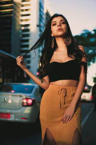 Woman posing in a skirt with two deep slits and a black crop top