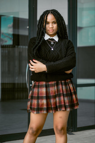 Girl posing in short pleated skirt and black sweatshirt