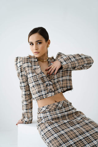 Woman posing in a brown checked suit