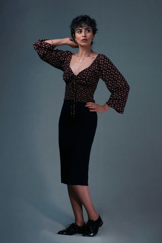Woman posing with midi-length pencil skirt and dark blouse