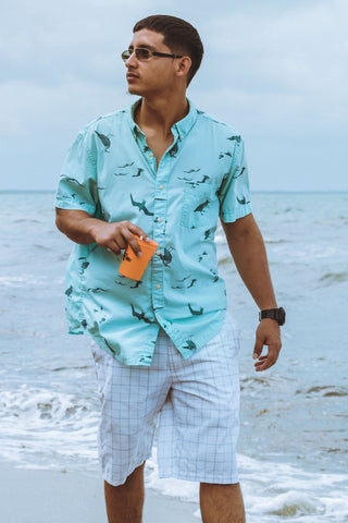 A man on the beach wearing aloha shirt