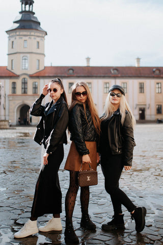Trois filles posant sur une place dans de belles tenues d'automne