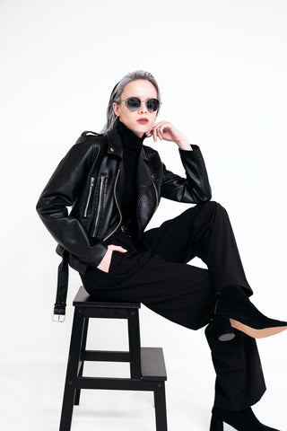 Woman sitting wearing a black leather monochrome outfit