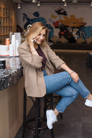 Girl talking on the phone wearing jeans and a blazer