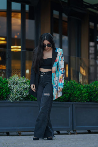 Woman wearing a graphic blazer over a crop top and jeans