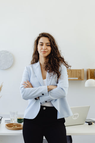 Woman posing for a photo wearing a fitted blazer and black chinos