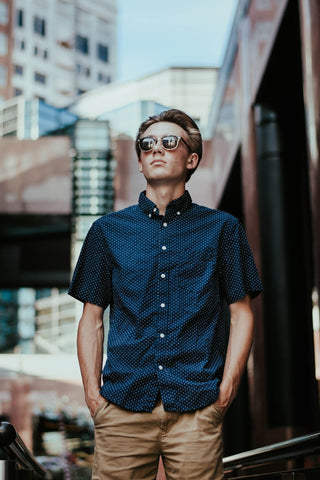 Man posing with navy patterned short-sleeved shirt and khaki