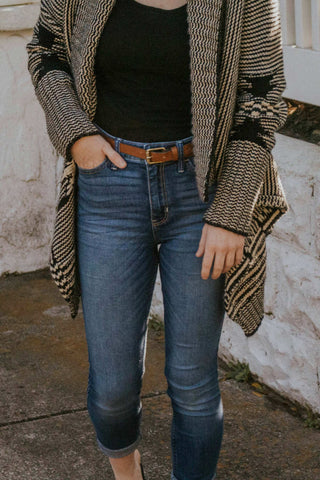 Woman torso wearing skinny jeans and long cardigan over a black top