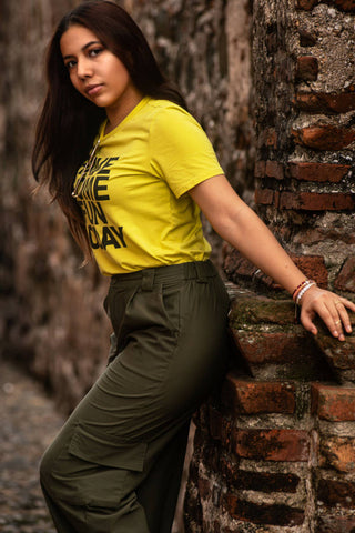 Girl posing with a yellow tee and green cargo pants