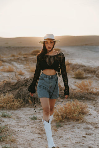 woman posing with denim shorts and white cowboy boots